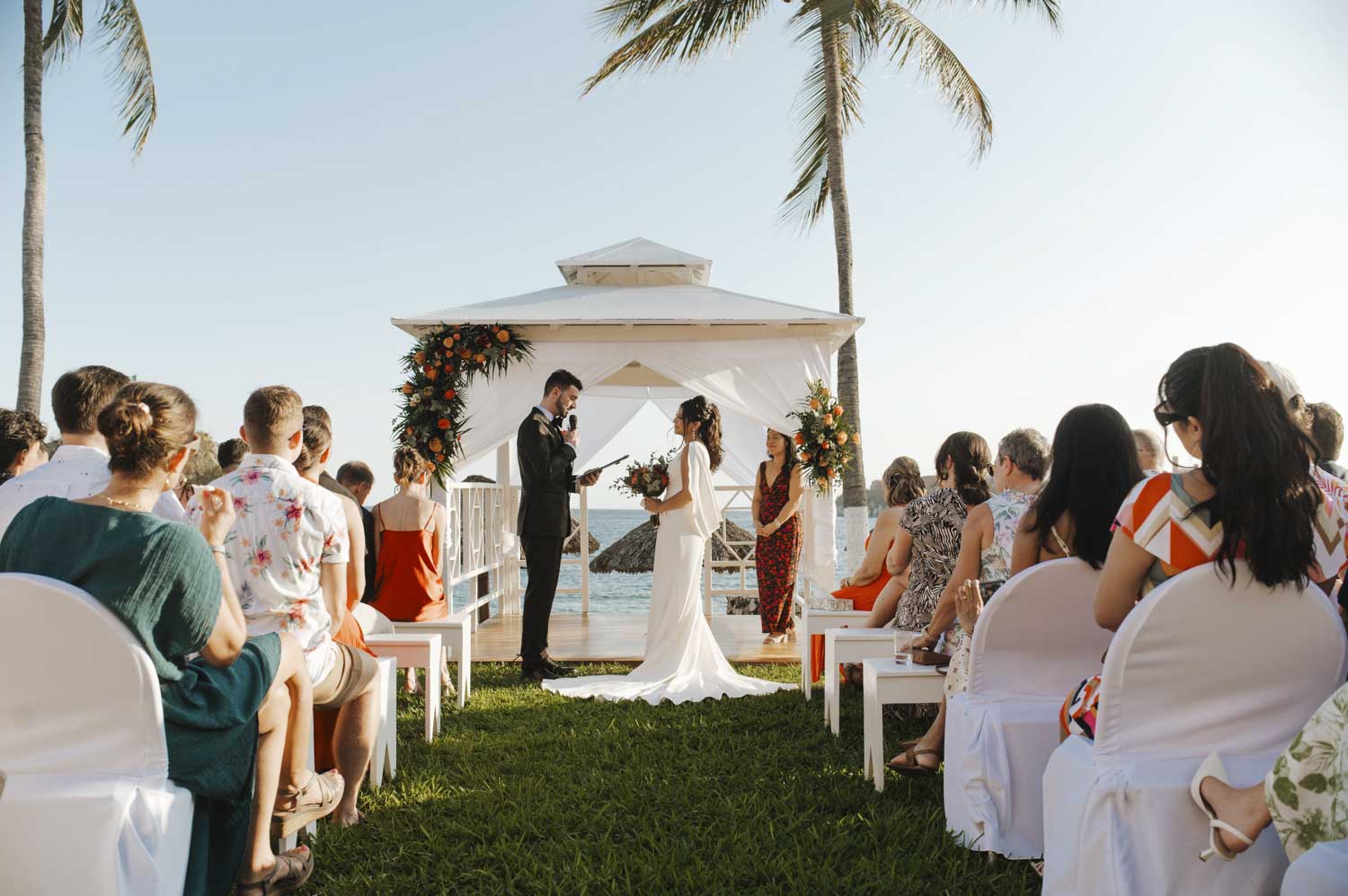 utdoor beachfront ceremony at Barceló Huatulco with vibrant florals and heartfelt vows during an upbeat Oaxaca beach wedding.